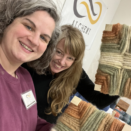 two women holding woven footstools